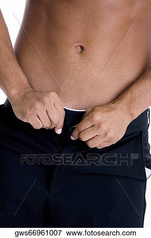 Stock Photo - Mid section view of a man buttoning his pants. Fotosearch