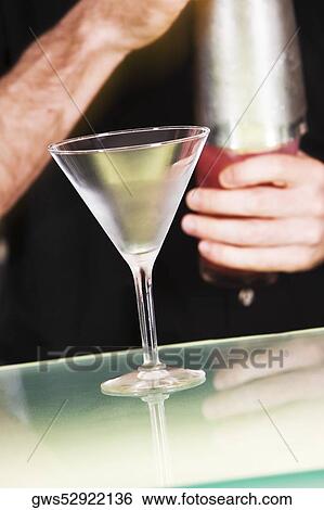 Mid section view of a man holding a cocktail shaker View Large Photo Image Stock Photograph - Mid section view of a man holding a cocktail shaker. Fotosearch