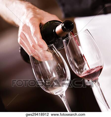 Mid section view of a man pouring red wine into a wineglass View Large Photo Image Stock Image - Mid section view of a man pouring red wine into a wineglass. Fotosearch