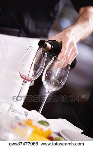 Mid section view of a man pouring red wine into a wineglass View Large Photo Image Stock Photograph - Mid section view of a man pouring red wine into a wineglass. Fotosearch