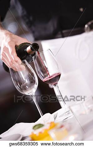 Mid section view of a man pouring red wine into a wineglass View Large Photo Image Stock Photography - Mid section view of a man pouring red wine into a wineglass. Fotosearch