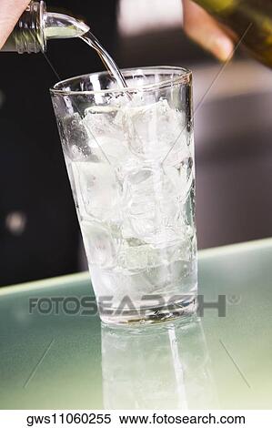 Mid section view of a man pouring alcohol into a glass filled with ice View Large Photo Image Stock Photography - Mid section view of a man pouring alcohol into a glass filled with ice. Fotosearch