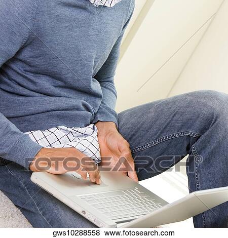 Mid section view of a mid adult man using a laptop View Large Photo Image Stock Photo - Mid section view of a mid adult man using a laptop. Fotosearch