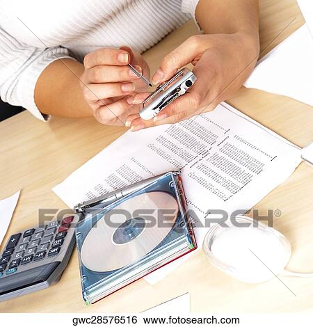 Stock Photograph - Mid section view of a woman using a personal data assistant. Fotosearch