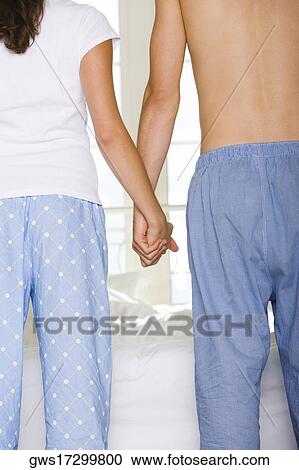 Mid section view of a young couple holding hands View Large Photo Image Stock Image - Mid section view of a young couple holding hands. Fotosearch