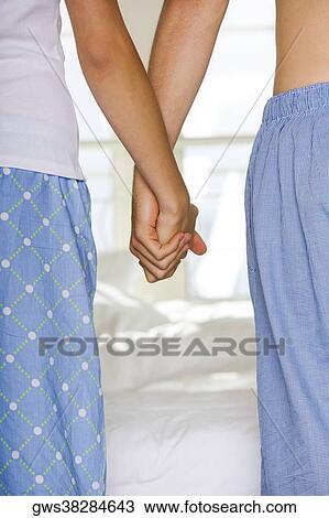Mid section view of a young couple holding hands View Large Photo Image Stock Image - Mid section view of a young couple holding hands. Fotosearch