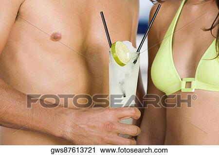 Mid section view of a young man holding lemonade with a young woman standing beside him View Large Photo Image Stock Image - Mid section view of a young man holding lemonade with a young woman standing beside him. Fotosearch