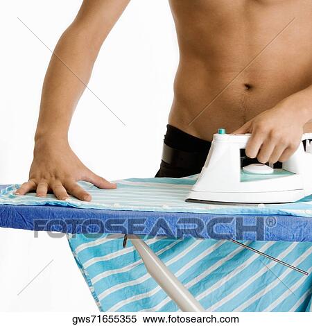 Mid section view of a young man ironing his shirt View Large Photo Image Stock Photography - Mid section view of a young man ironing his shirt. Fotosearch