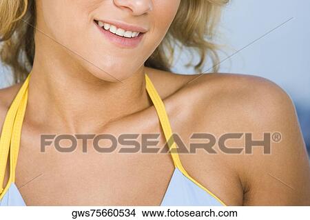 Picture - Mid section view of a young woman smiling. Fotosearch
