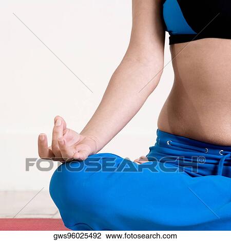 Mid section view of a young woman performing yoga View Large Photo Image Stock Image - Mid section view of a young woman performing yoga. Fotosearch