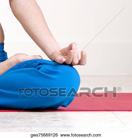 Mid section view of a young woman performing yoga View Large Photo Image Stock Photograph - Mid section view of a young woman performing yoga. Fotosearch