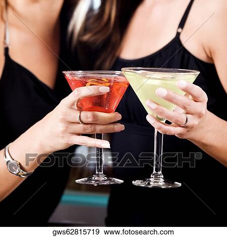 Download Mid section view of two young women toasting martinis Stock Photo | gws62815719 | Fotosearch