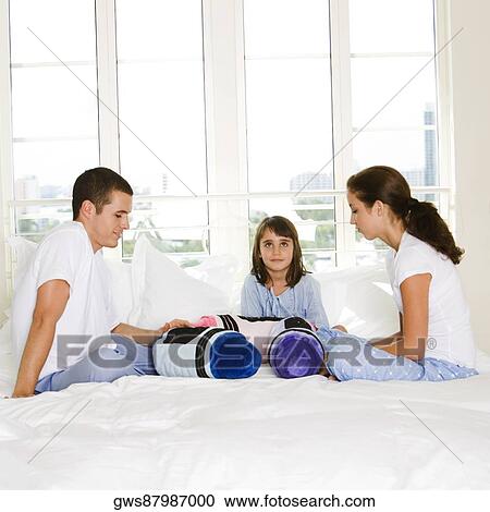 Parents and their daughter sitting on the bed View Large Photo Image Stock Image - Parents and their daughter sitting on the bed. Fotosearch