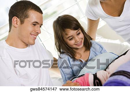 Parents and their daughter sitting on the bed View Large Photo Image Stock Photo - Parents and their daughter sitting on the bed. Fotosearch