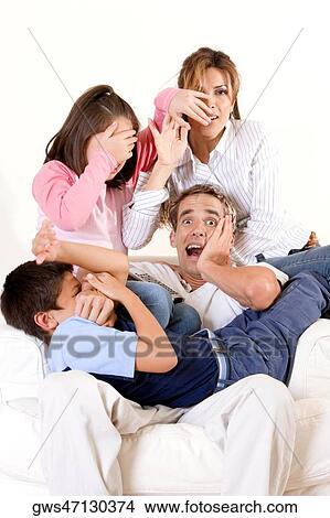 Picture - Parents and their two children covering their faces. Fotosearch