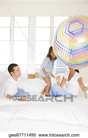Stock Photography - Parents playing with their daughter. Fotosearch