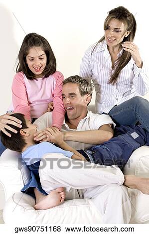 Parents sitting with their son and daughter on an armchair View Large Photo Image Stock Photo - Parents sitting with their son and daughter on an armchair. Fotosearch