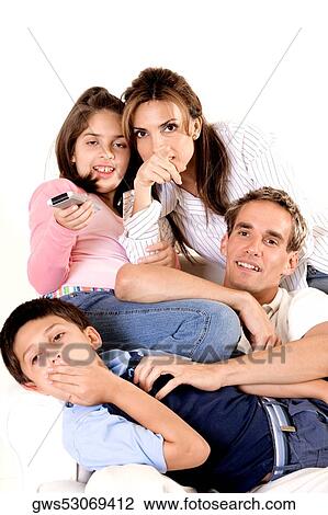 Stock Image - Parents watching television with their son and daughter. Fotosearch