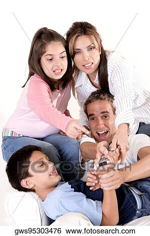 Parents with their son and daughter pressing buttons on a remote control View Large Photo Image Stock Photograph - Parents with their son and daughter pressing buttons on a remote control. Fotosearch