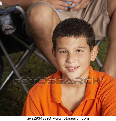 Portrait of a boy sitting in front of a man View Large Photo Image Stock Image - Portrait of a boy sitting in front of a man. Fotosearch
