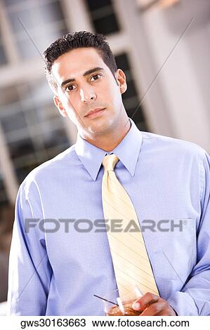 Stock Image - Portrait of a businessman holding a glass of wine. Fotosearch
