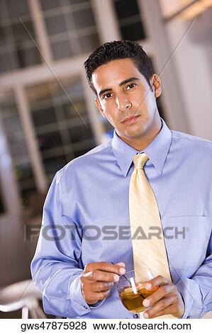 Stock Photo - Portrait of a businessman holding a glass. Fotosearch