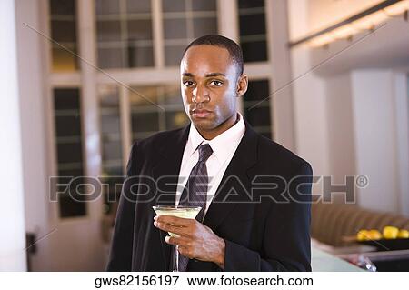 Portrait of a businessman holding a glass of martini View Large Photo Image Stock Photo - Portrait of a businessman holding a glass of martini. Fotosearch