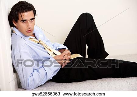 Stock Image - Portrait of a businessman reclining against a wall. Fotosearch