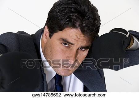 Stock Image - Portrait of a businessman wearing boxing gloves. Fotosearch