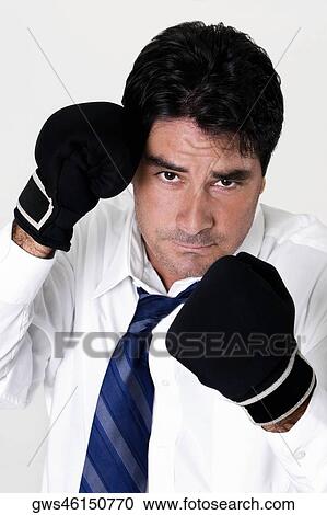 Stock Image - Portrait of a businessman wearing boxing gloves. Fotosearch