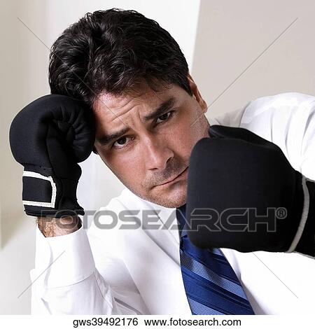 Stock Photograph - Portrait of a businessman wearing boxing gloves. Fotosearch