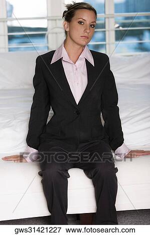 Stock Photo - Portrait of a businesswoman sitting on the bed. Fotosearch
