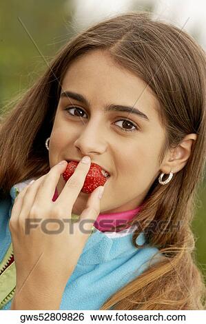 Portrait of a girl eating a strawberry View Large Photo Image Stock Photograph - Portrait of a girl eating a strawberry. Fotosearch