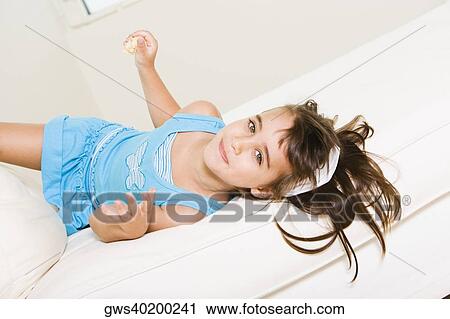 Portrait of a girl lying down on the bed View Large Photo Image Stock Image - Portrait of a girl lying down on the bed. Fotosearch