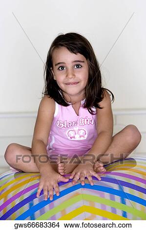 Picture - Portrait of a girl sitting on an inflatable ball. Fotosearch