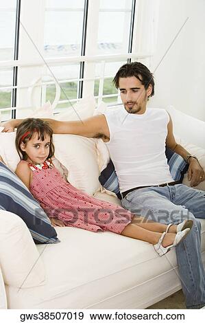 Stock Photo - Portrait of a girl sitting with her father. Fotosearch