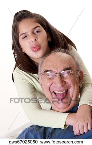 Portrait of a granddaughter sticking out her tongue and hugging her grandfather View Large Photo Image Stock Image - Portrait of a granddaughter sticking out her tongue and hugging her grandfather. Fotosearch