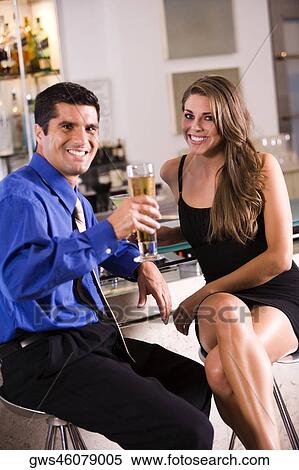 Portrait of a mid adult man and a young woman sitting in a bar View Large Photo Image Stock Photography - Portrait of a mid adult man and a young woman sitting in a bar. Fotosearch