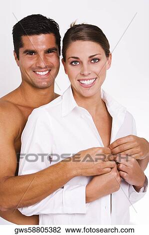 Portrait of a mid adult man buttoning a young woman's shirt View Large Photo Image Stock Image - Portrait of a mid adult man buttoning a young woman's shirt. Fotosearch