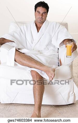 Portrait of a mid adult man holding a glass of juice View Large Photo Image Picture - Portrait of a mid adult man holding a glass of juice. Fotosearch