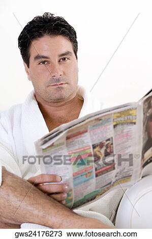 Stock Image - Portrait of a mid adult man holding a newspaper. Fotosearch