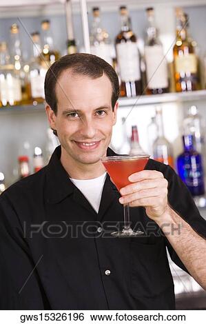 Stock Photograph - Portrait of a mid adult man holding a cocktail. Fotosearch