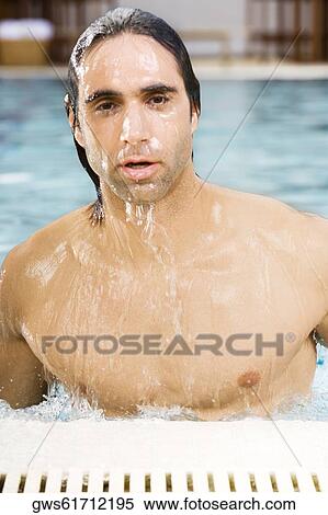 Stock Photography - Portrait of a mid adult man in a swimming pool. Fotosearch