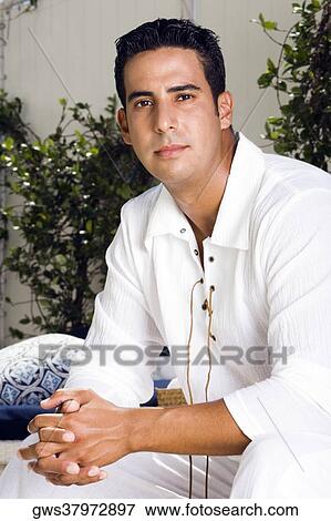 Portrait of a mid adult man sitting with his hands clasped View Large Photo Image Stock Photo - Portrait of a mid adult man sitting with his hands clasped. Fotosearch