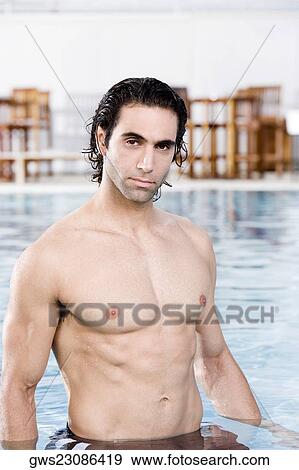 Stock Photo - Portrait of a mid adult man standing in a swimming pool. Fotosearch