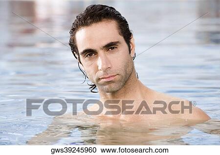 Stock Image - Portrait of a mid adult man swimming in a swimming pool. Fotosearch