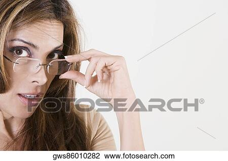 Portrait of a mid adult woman adjusting her eyeglasses View Large Photo Image Stock Image - Portrait of a mid adult woman adjusting her eyeglasses. Fotosearch