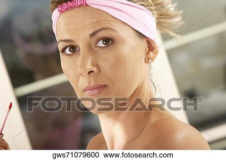 Portrait of a mid adult woman holding a lip liner View Large Photo Image Stock Image - Portrait of a mid adult woman holding a lip liner. Fotosearch