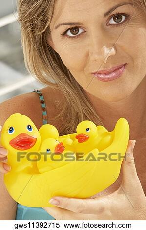 Portrait of a mid adult woman holding rubber ducks View Large Photo Image Stock Photography - Portrait of a mid adult woman holding rubber ducks. Fotosearch