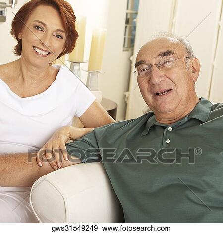 Portrait of a senior couple sitting together and smiling View Large Photo Image Stock Photo - Portrait of a senior couple sitting together and smiling. Fotosearch